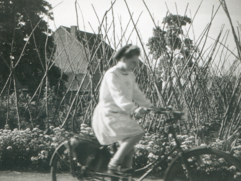 Meisje op de fiets bij een moestuin.